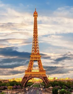 a tall metal tower with Eiffel Tower in the background