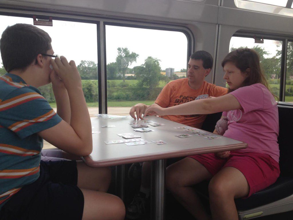 a group of people sitting at a table playing cards