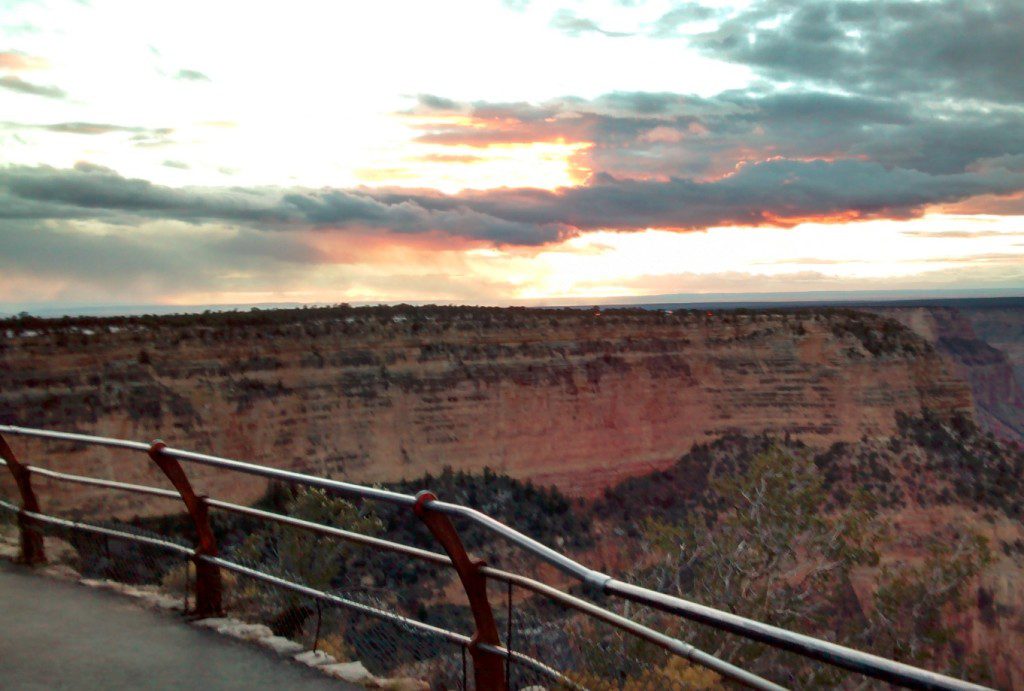 a road with a railing overlooking a canyon