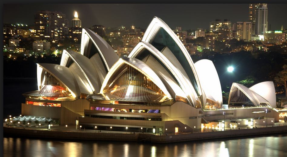 Sydney Opera House with pointed roof and a city in the background