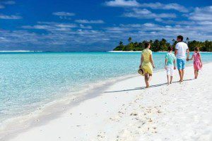 a woman and a boy walking on a beach