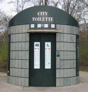 a public toilet with signs on the door