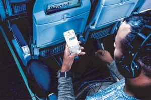 a man sitting in an airplane with a phone