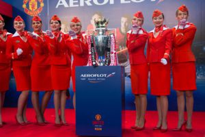 a group of women in red uniforms standing next to a trophy