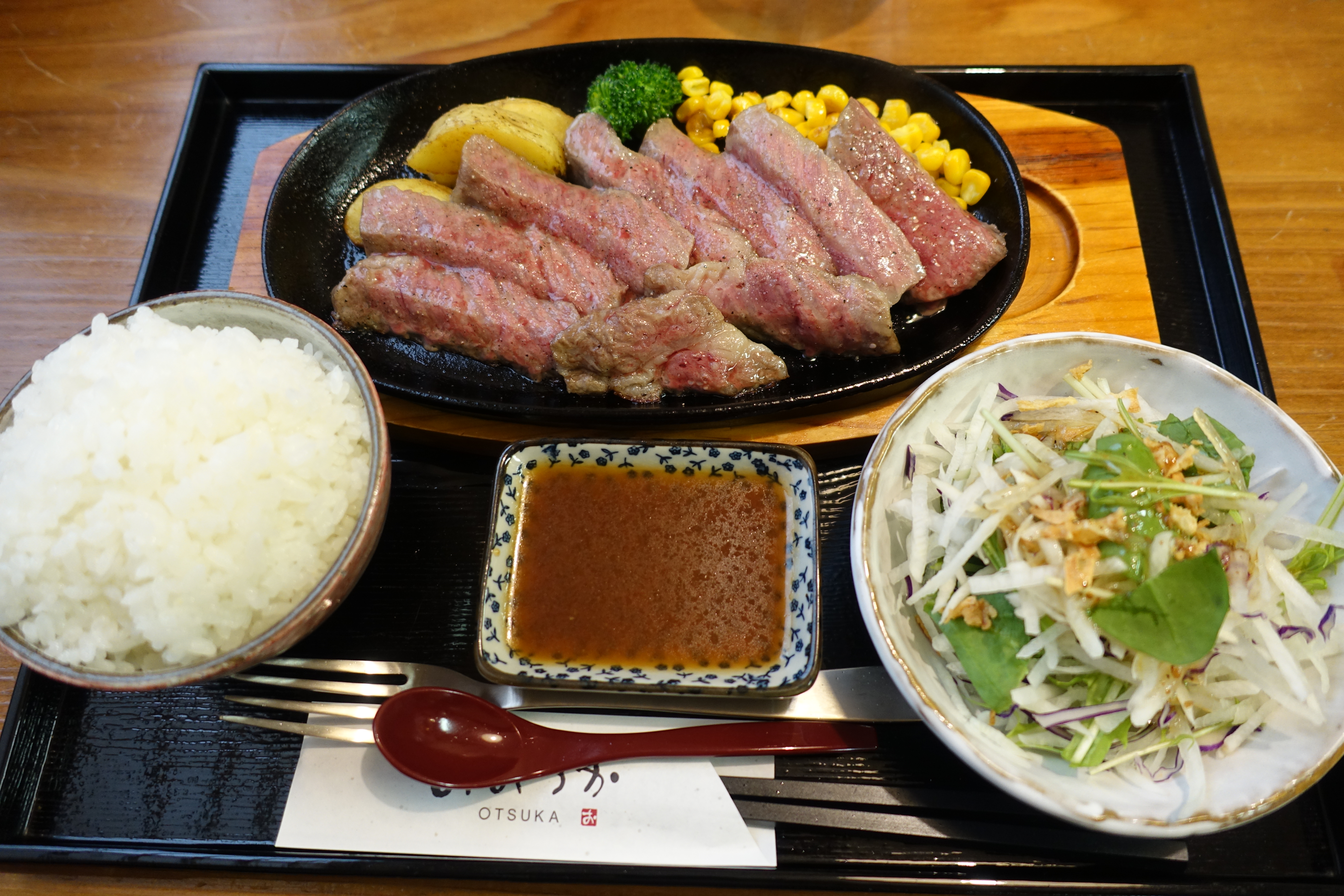 Steak meal served on one tray with rice and salad.