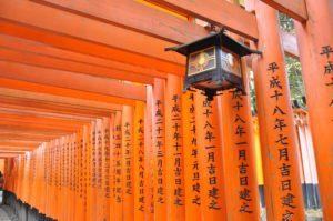 a lantern from a wall of orange pillars