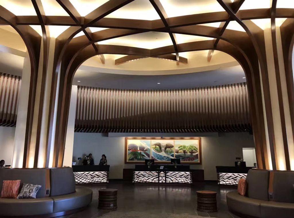 a lobby with a large ceiling and a couple of people standing behind it