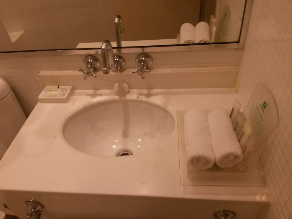 a sink with a mirror and towels