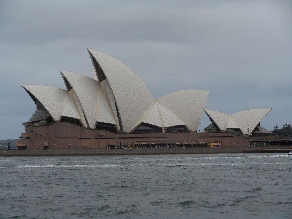 Sydney Opera House with pointed roof and a body of water