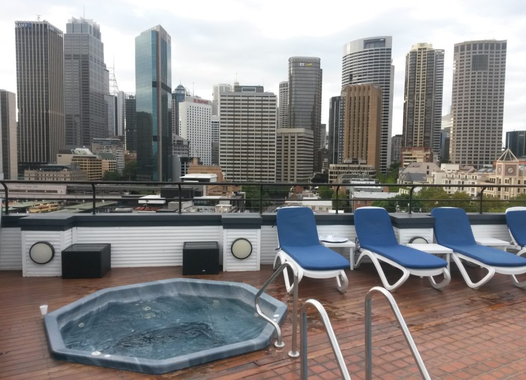 a hot tub on a rooftop with a city in the background