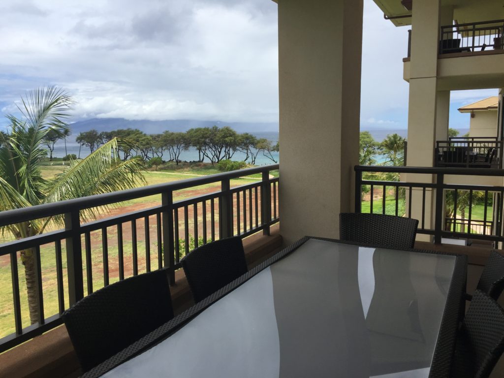 a table and chairs on a balcony overlooking a body of water