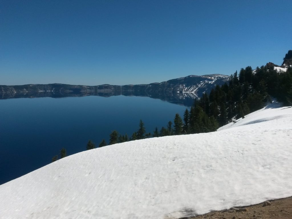 a snow covered hill next to a body of water