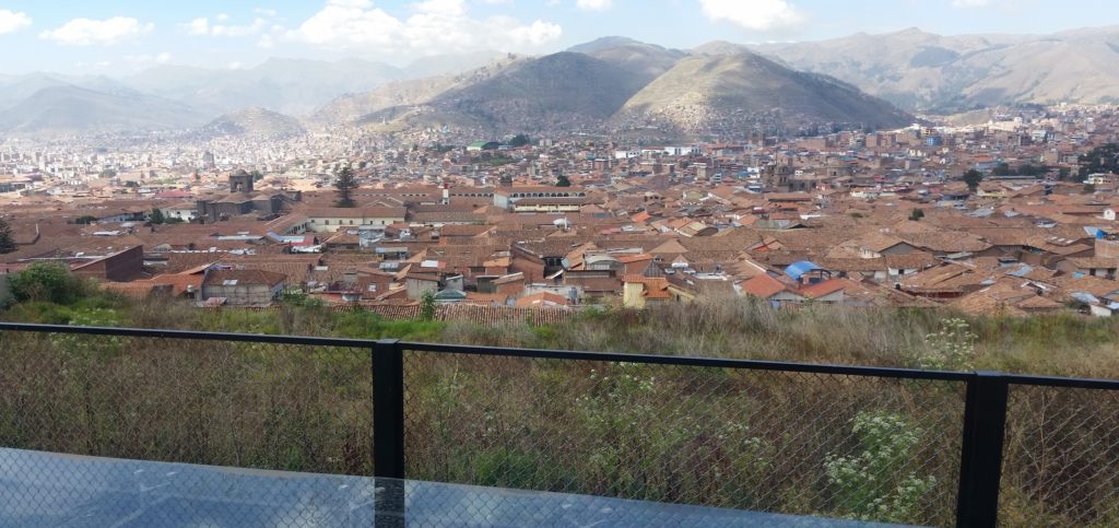 a city with a fence and mountains in the background