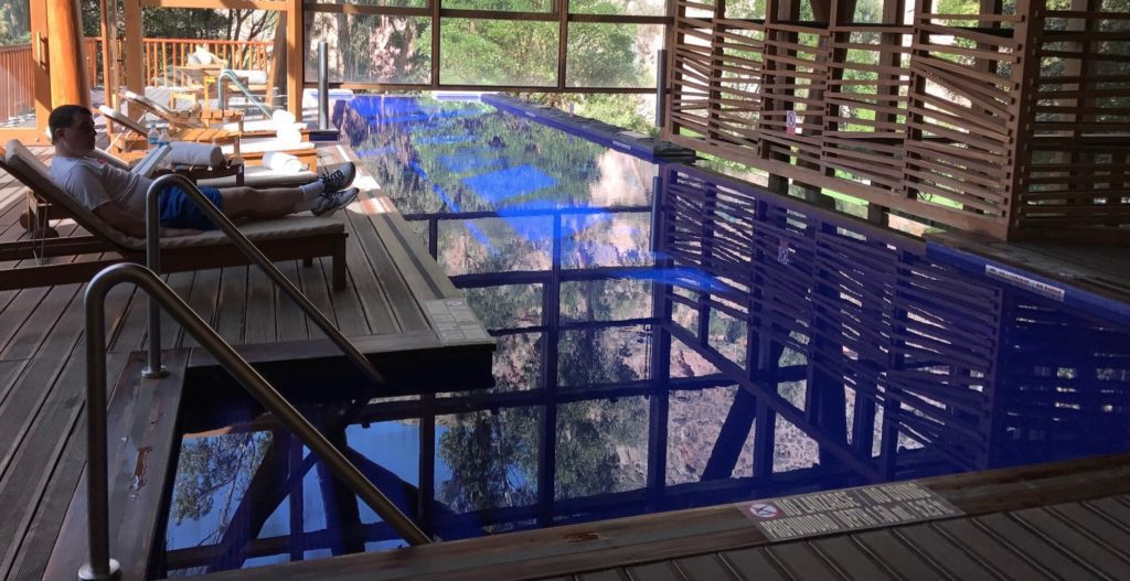 a pool with a wooden deck and a wooden railing