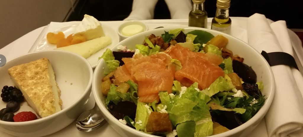 a bowl of salad with salmon and cheese