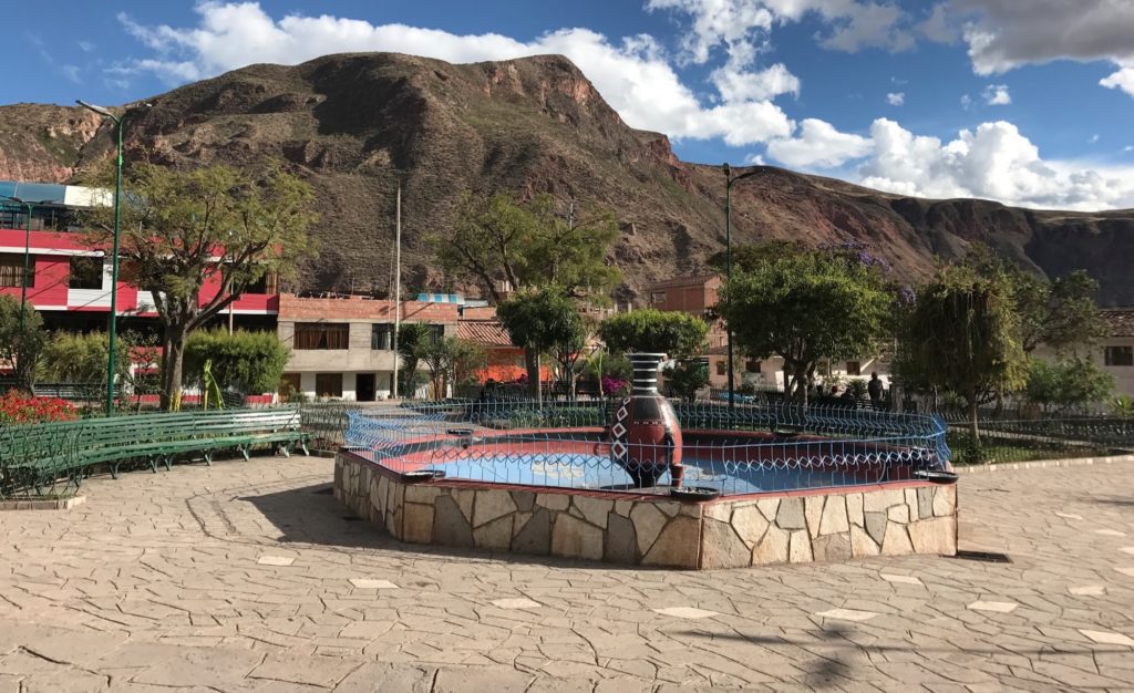 a fountain in a courtyard with a mountain in the background