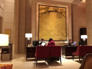 a group of people sitting at a desk in a hotel lobby