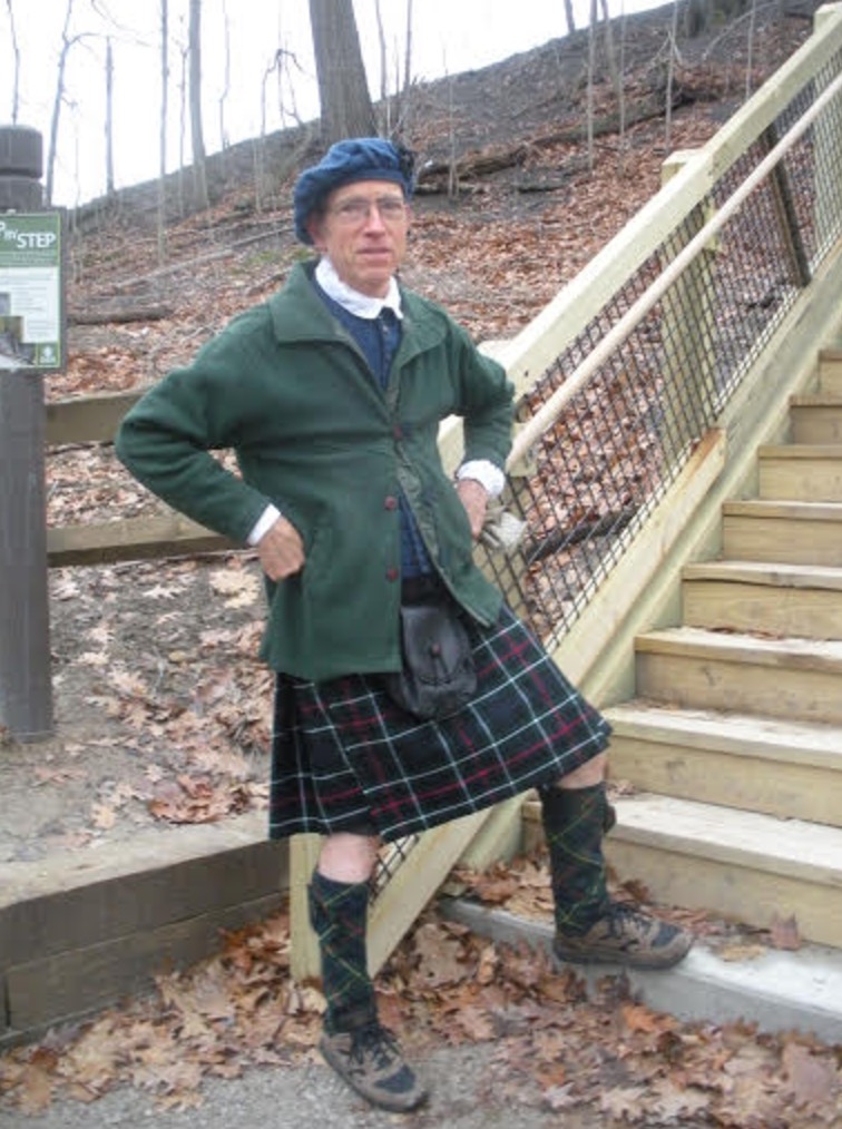 a man in a kilt standing on stairs