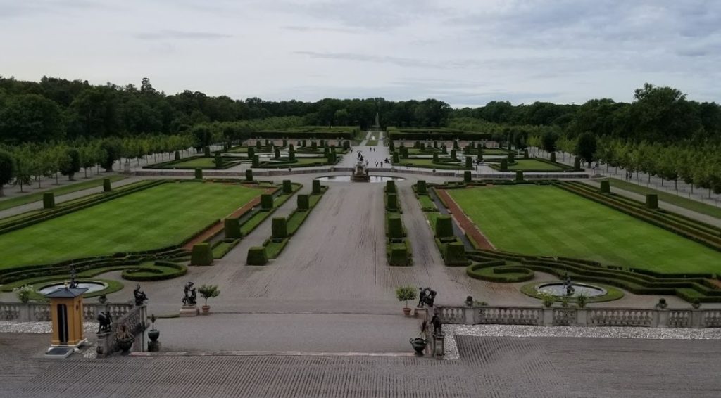 a large garden with a walkway and a fountain