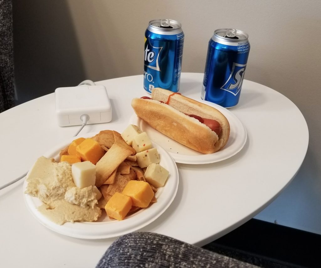 a plate of food and soda cans on a table