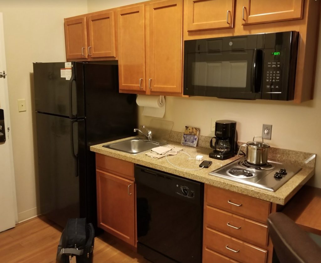 a kitchen with a black refrigerator and a black microwave