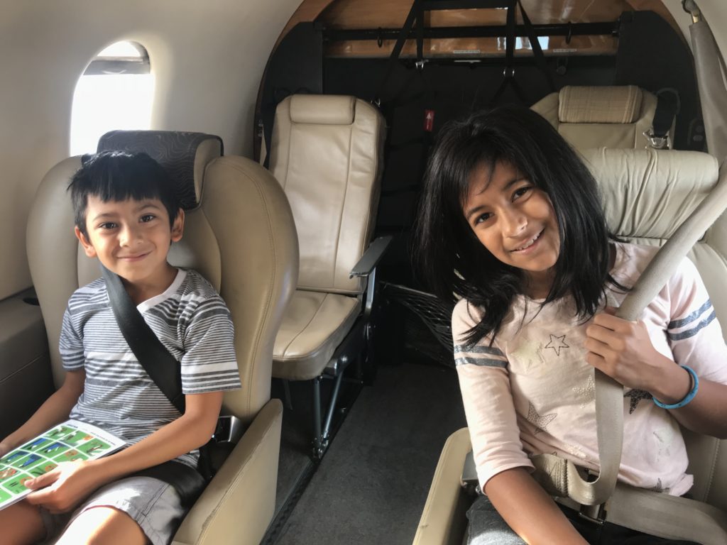 a boy and girl sitting in a plane