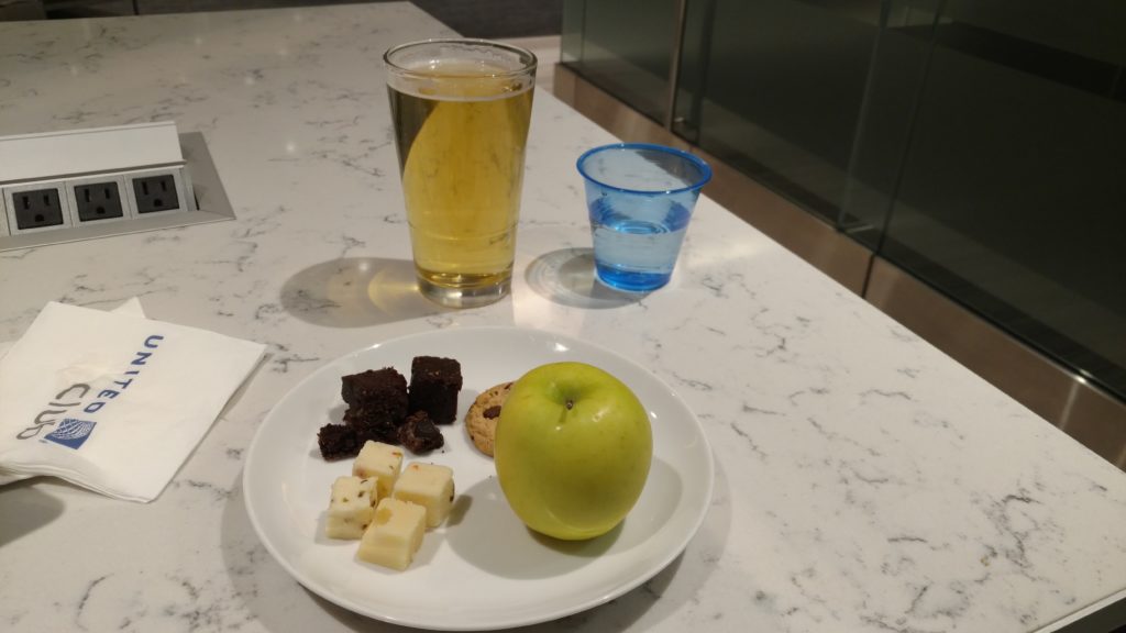 a plate of food and a glass of beer on a table