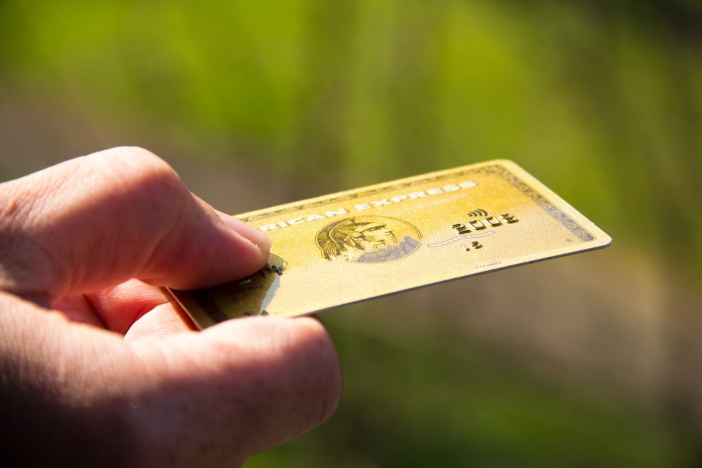 a hand holding a gold card