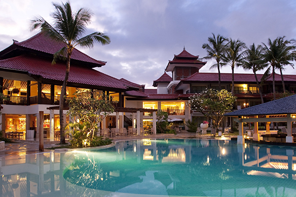 a pool with a building and palm trees