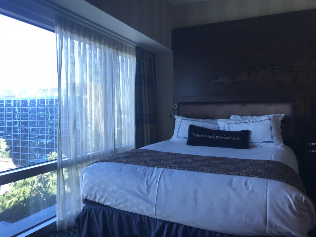 a bed with a large headboard and a window
