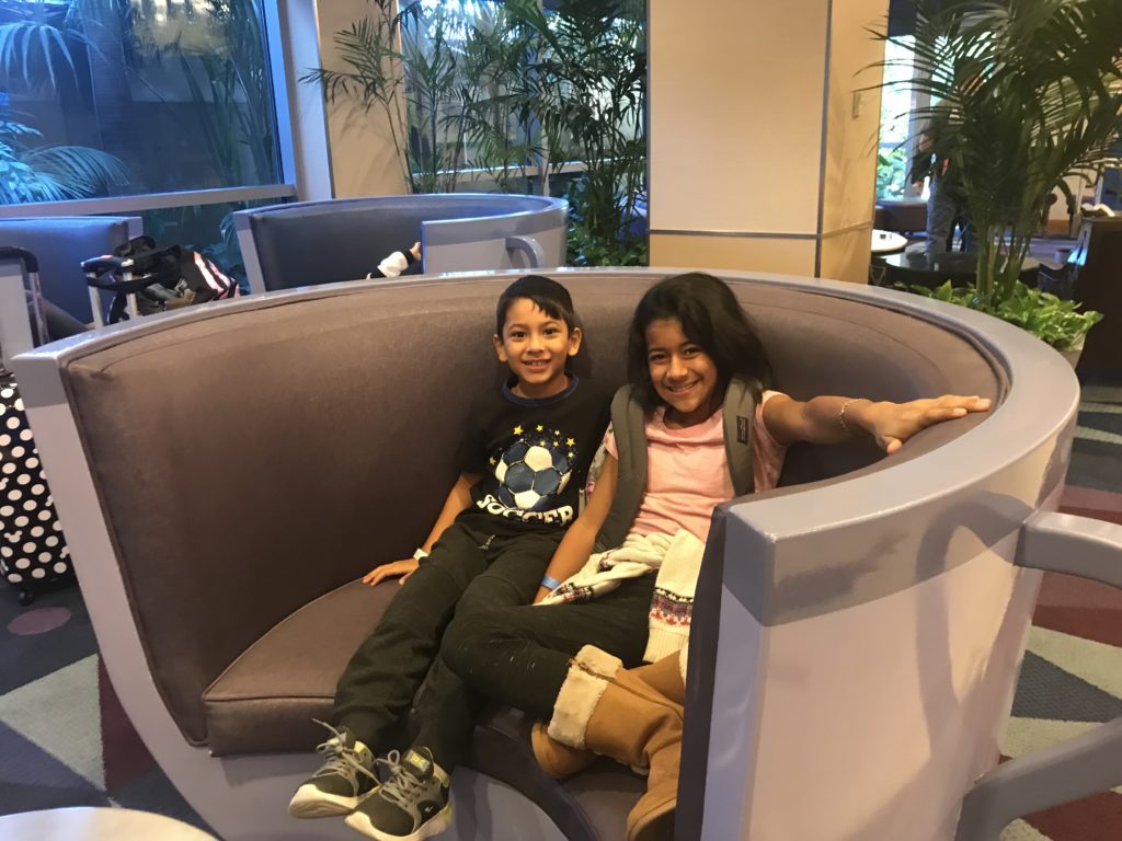 a boy and girl sitting on a round couch