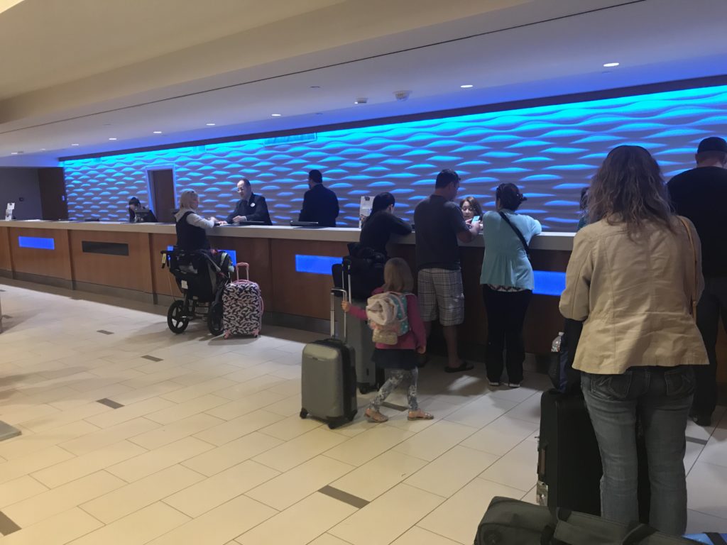people standing at a counter in a lobby