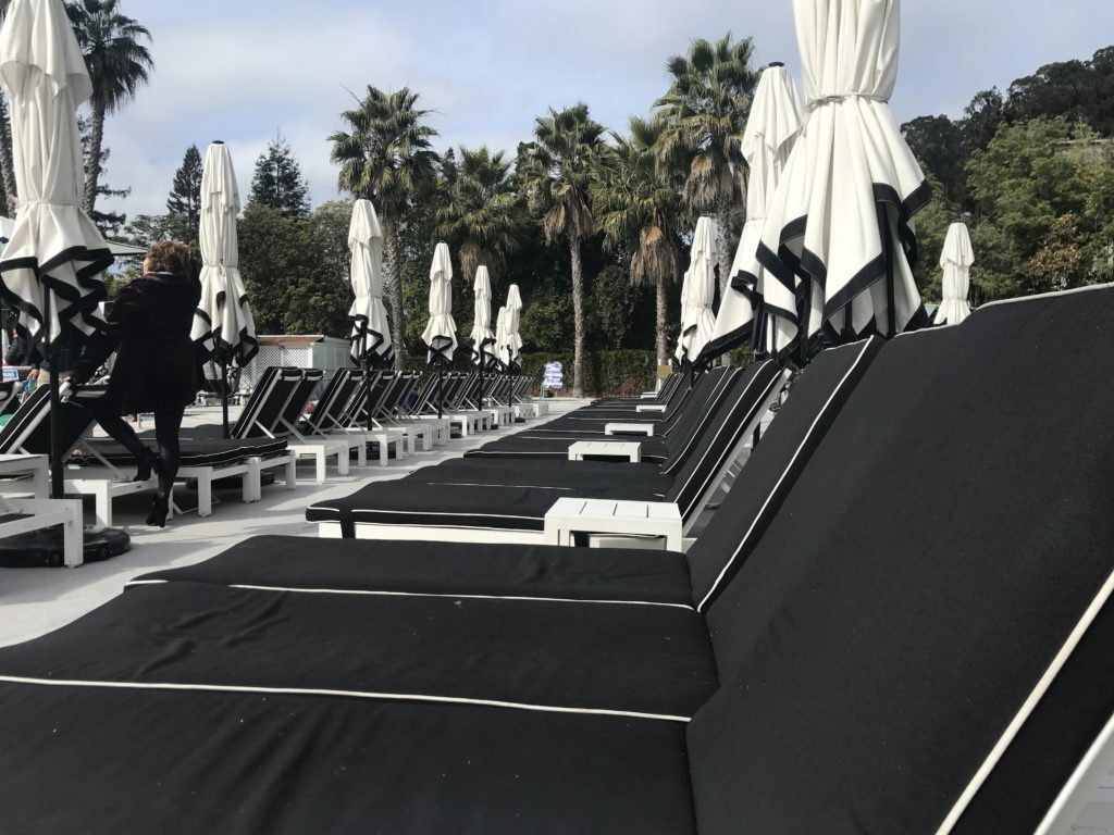 a group of black and white lounge chairs and umbrellas