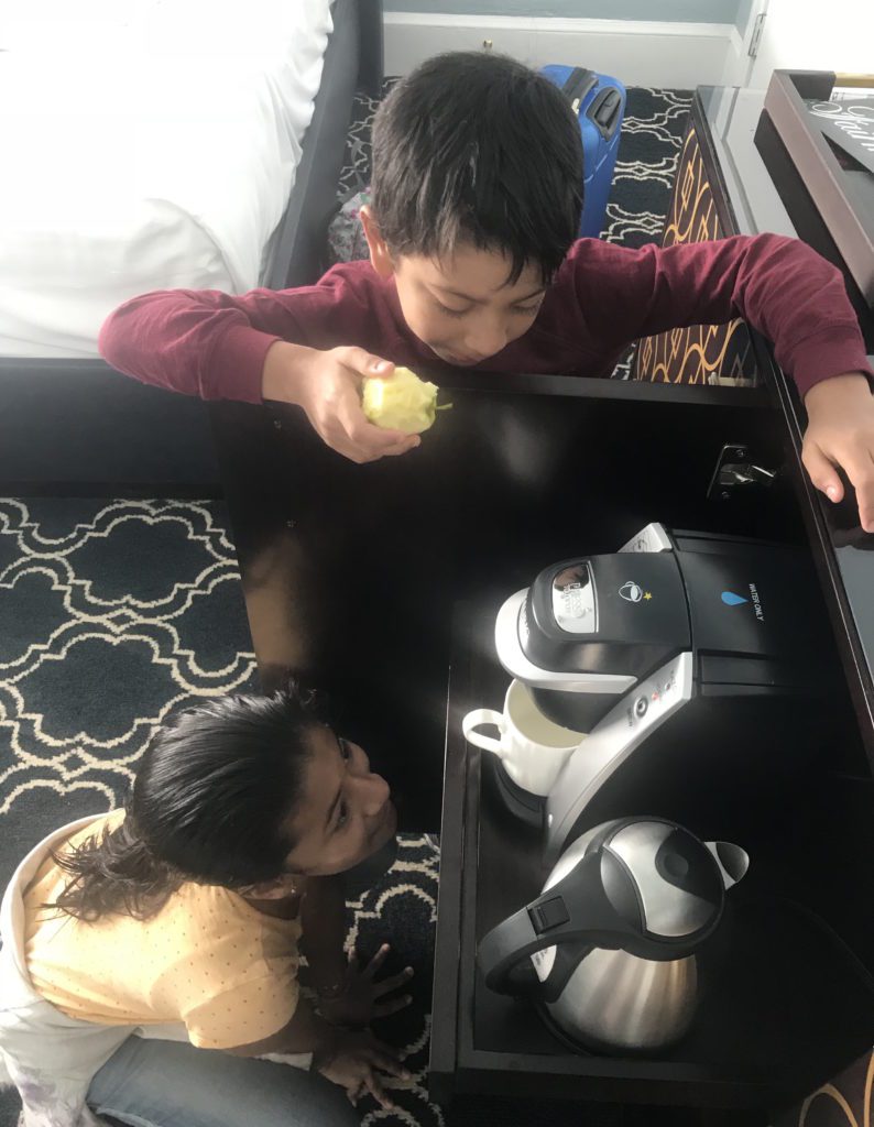 a boy and girl looking at a coffee machine