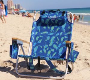 a blue folding chair on a beach