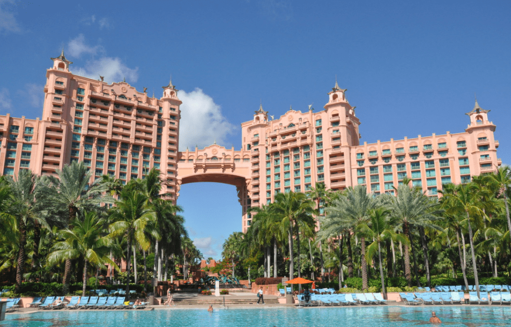 a large building with a pool and palm trees