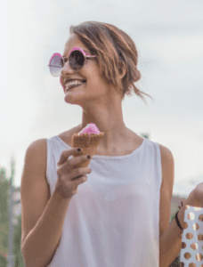 a woman wearing sunglasses and holding an ice cream cone