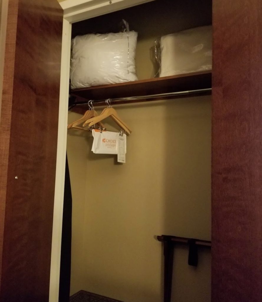 a closet with a shelf and swingers