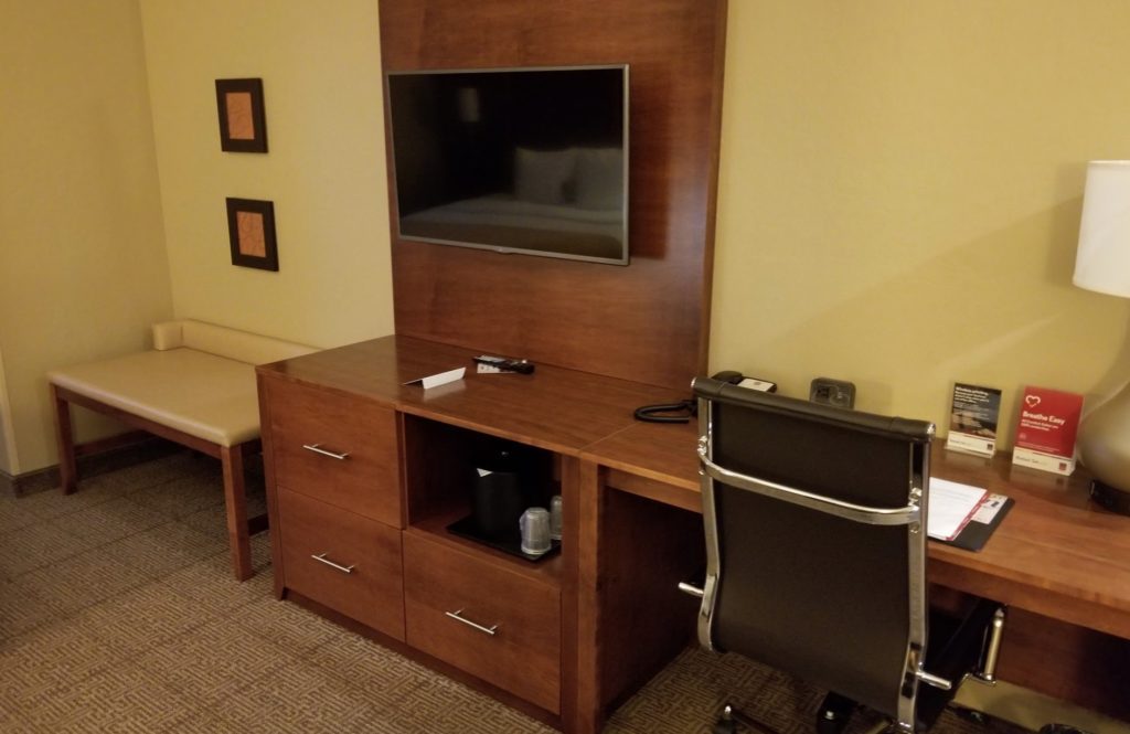 a desk with a tv and chair in a room
