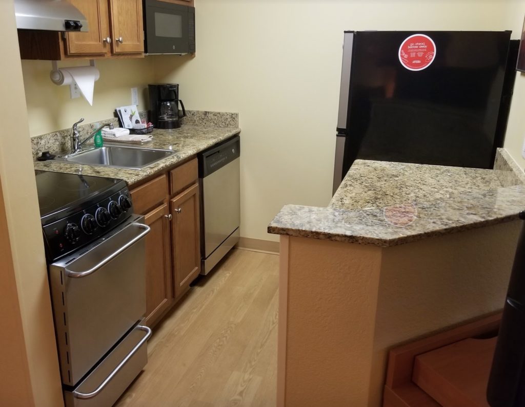 a kitchen with granite counter tops and a black refrigerator