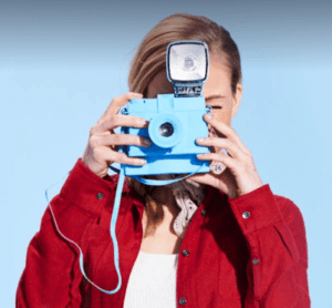 a woman holding a blue camera