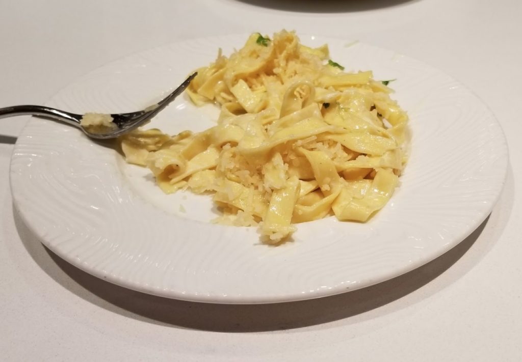 a plate of noodles and a spoon