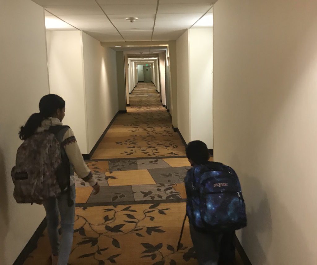 a couple of people walking in a hallway