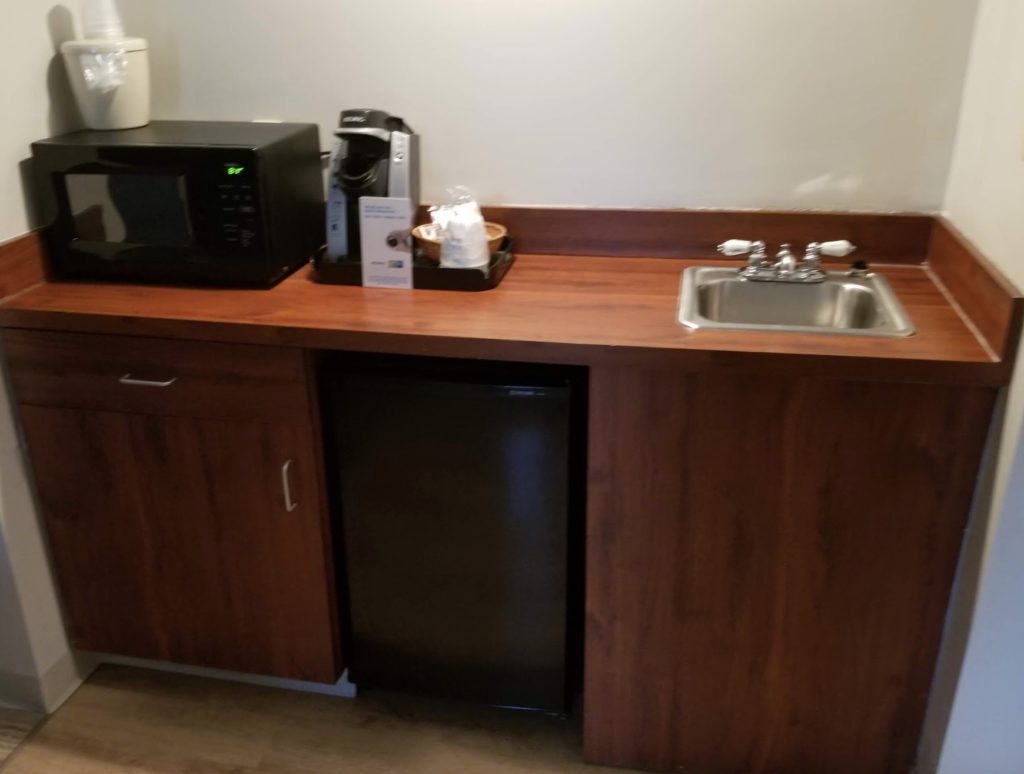 a kitchen counter with a microwave and a refrigerator