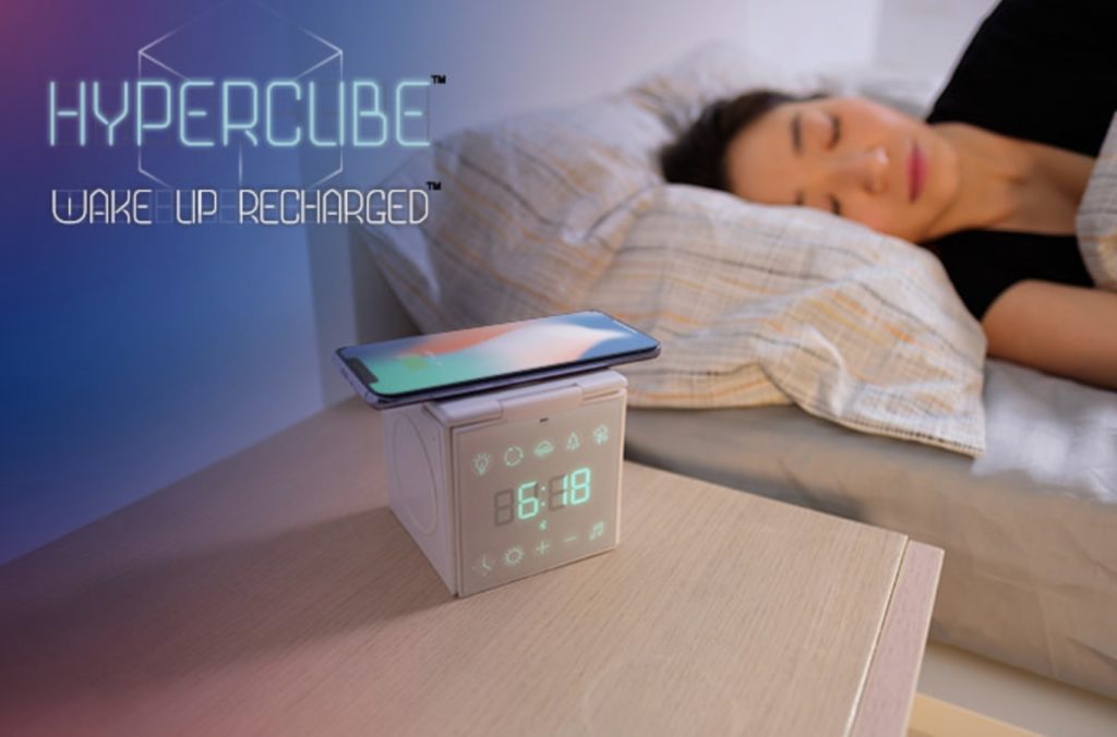 a woman sleeping in bed with a digital alarm clock