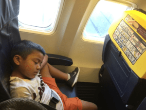 a boy sleeping on an airplane