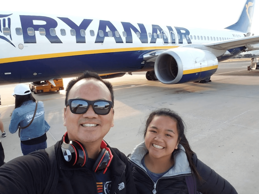 a man and woman taking a selfie in front of an airplane