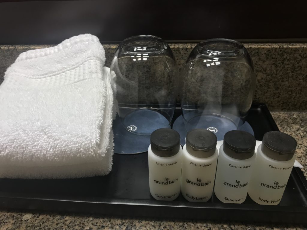 a group of white bottles and a towel on a tray