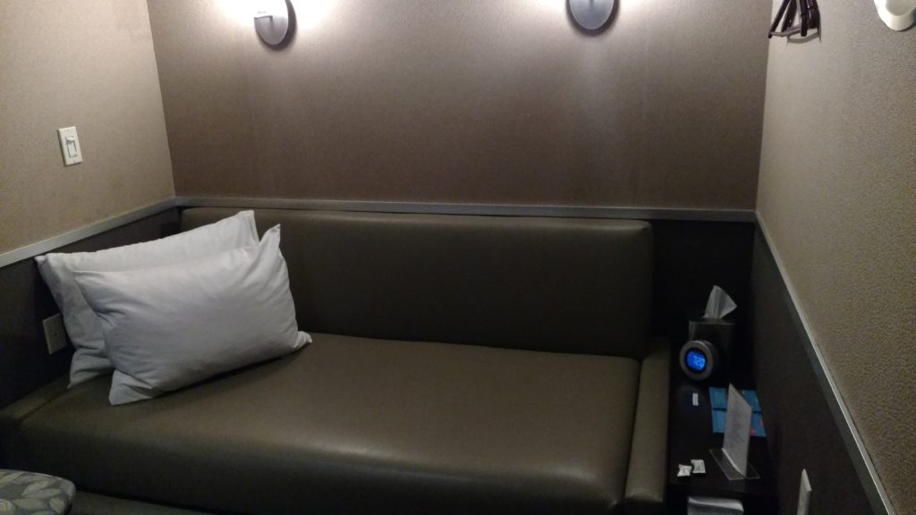 a couch with pillows and a clock on the wall