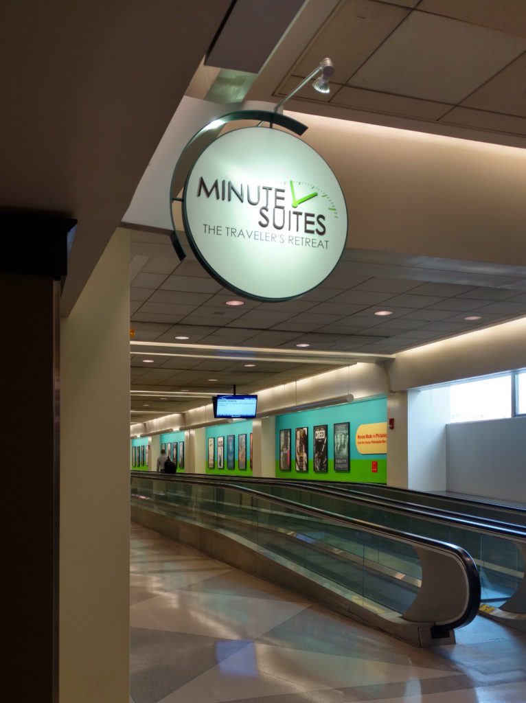 a sign on a sign above a moving escalator